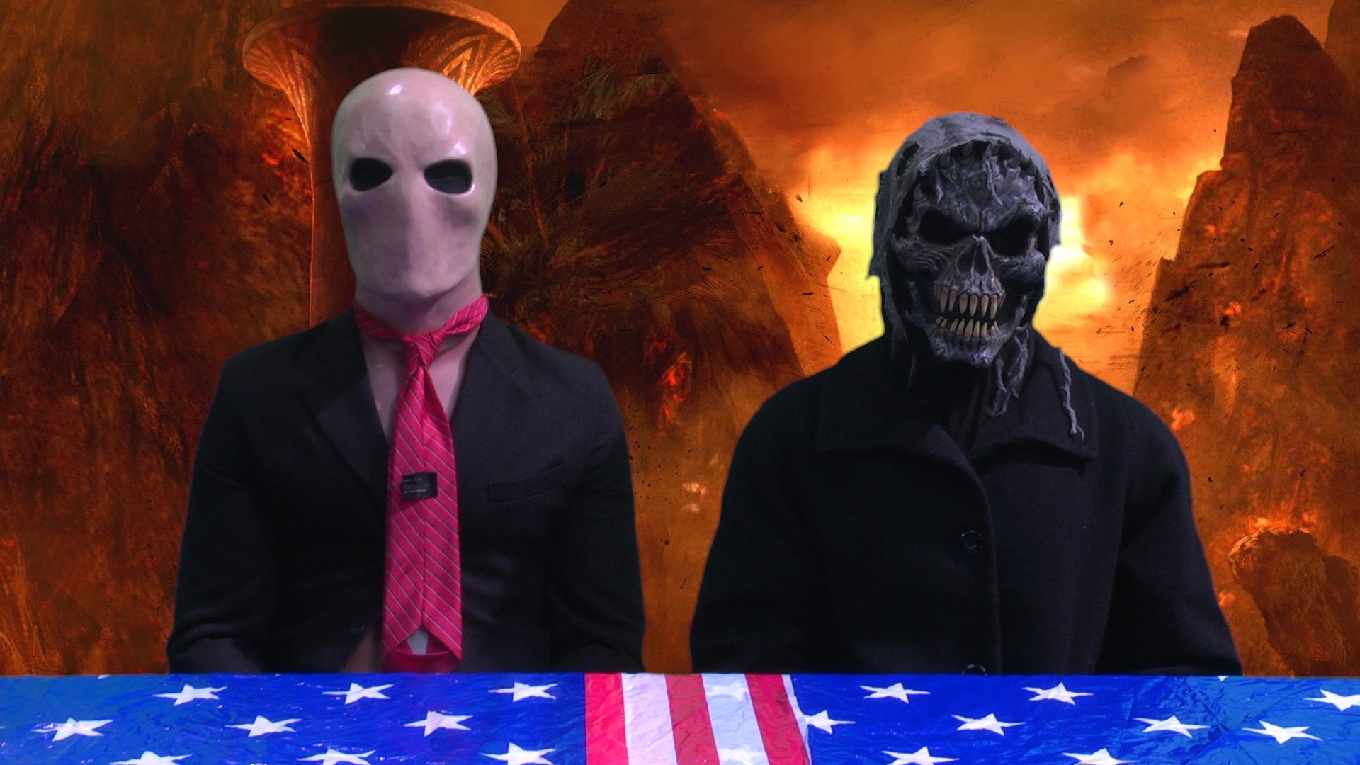 Image of two figures, one in white mask one in black devil mask in front of a background of fire