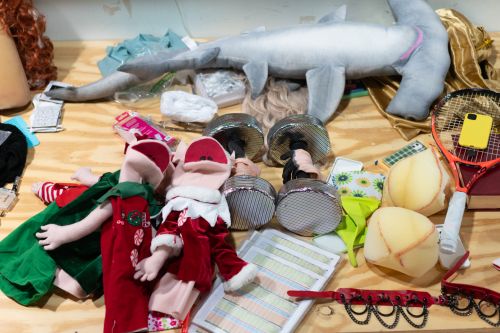 Costume table with elf puppets, barbell hands, and more