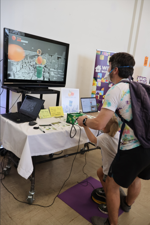 A father and son enjoying the interactive experience of TrashCan Dream together