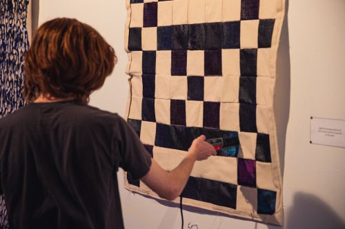 Person interacting with finished piece, heating up squares